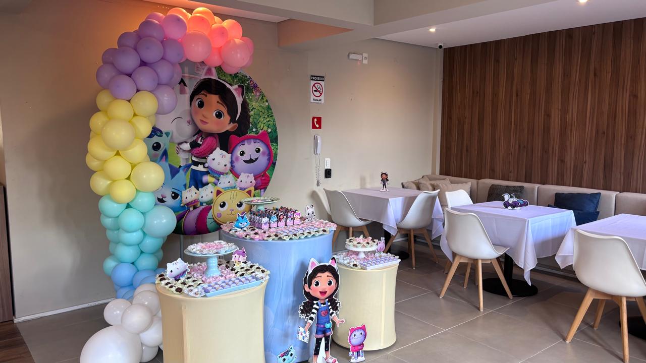 Decoração de festa infantil com arco de balões pastel e mesa de doces